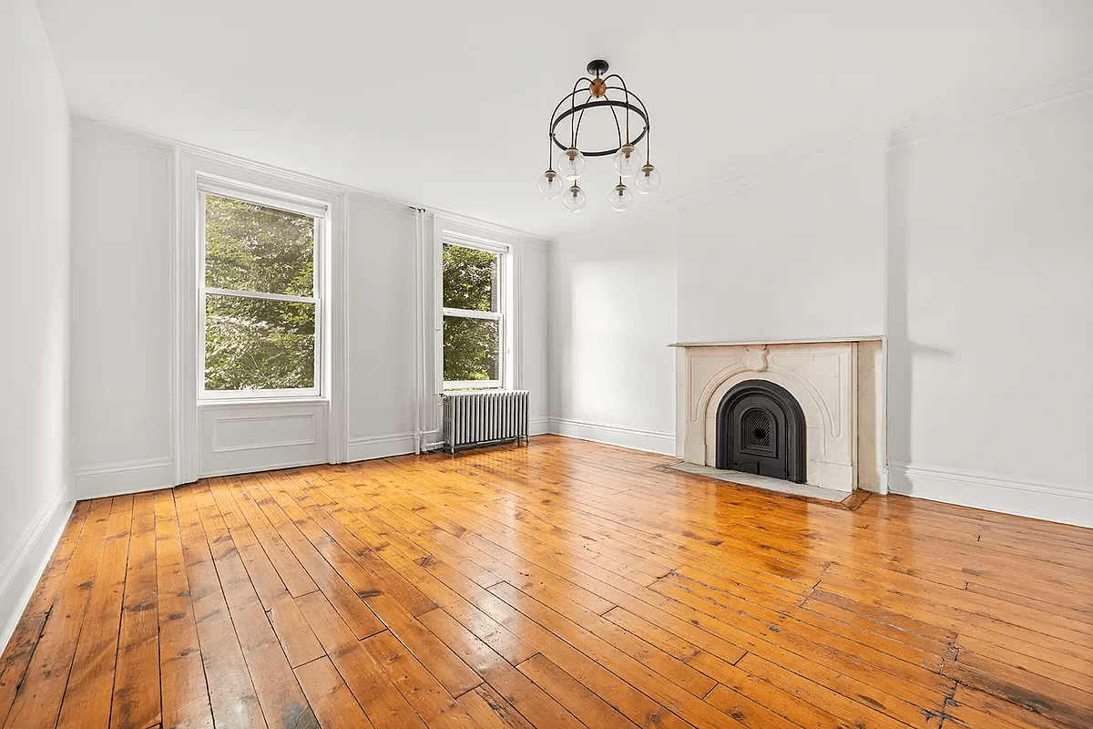 bedroom with marble mantel and wood floor