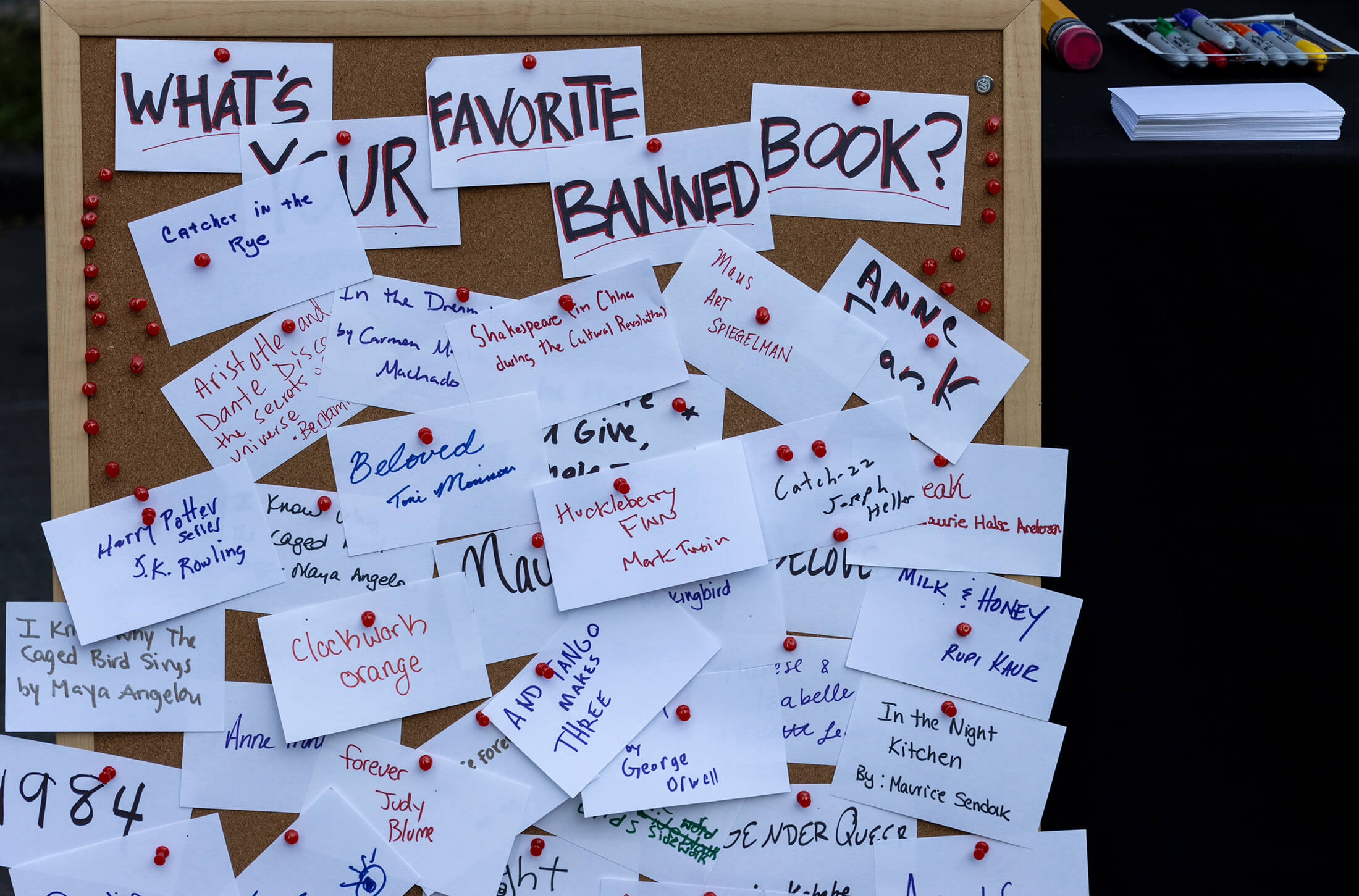 a bulletin board pinned with handwritten notes about peoples favorite banned books