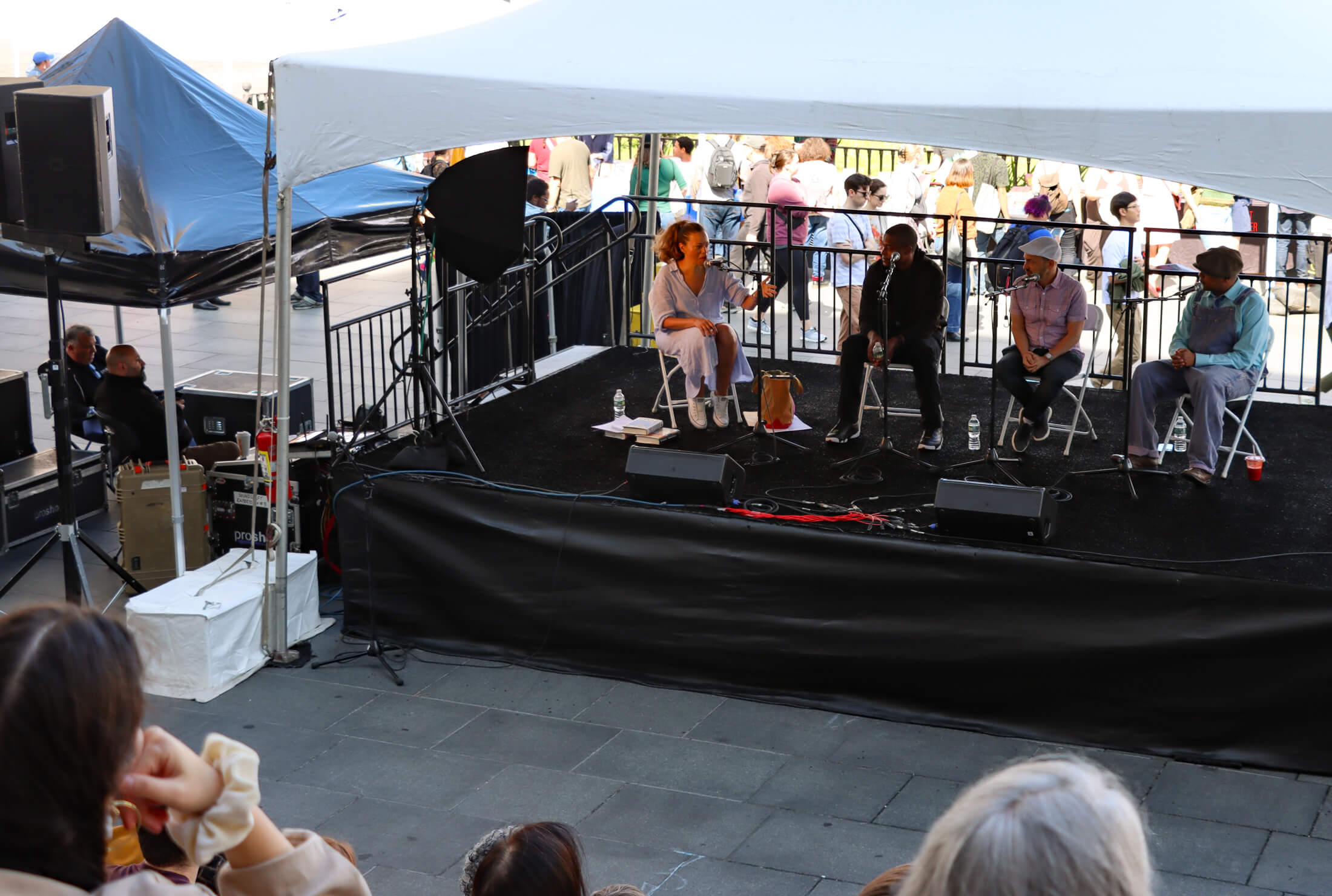 a view of the stage in front of borough hall and panelists speaking about hip hop