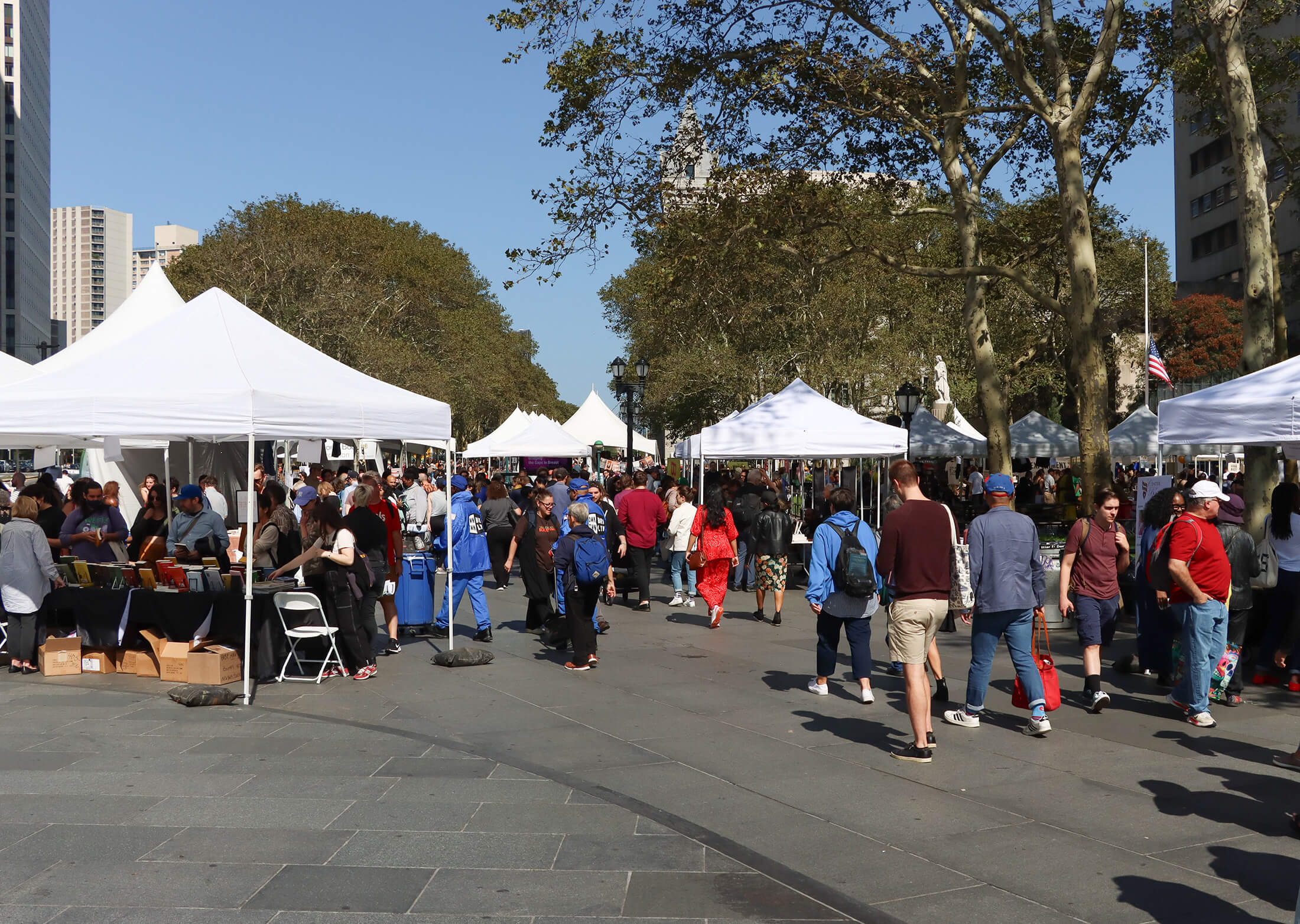 crowds walking by white tented book tables