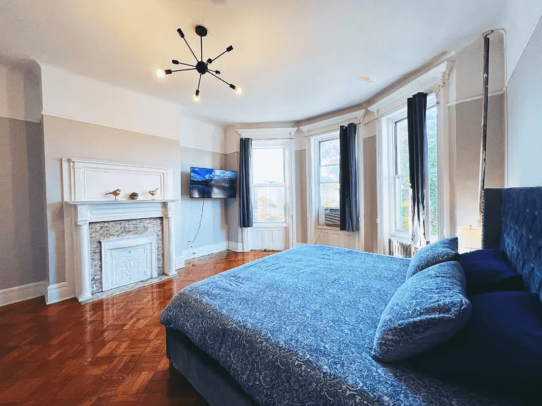 bedroom with mantel and three windows