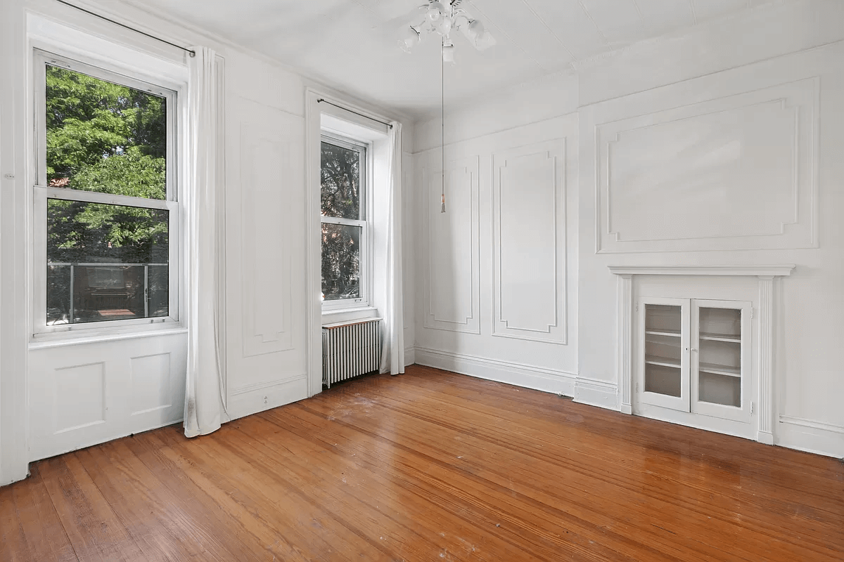 living room with wall moldings, wood floors and a built-in cabinet