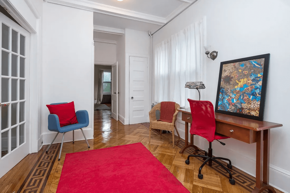 office area in the entry with wood floors, french doors to the bedroom