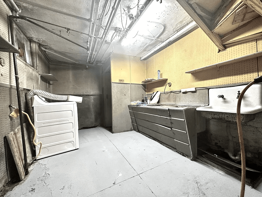 view of laundry area with peg board walls and vintage sink