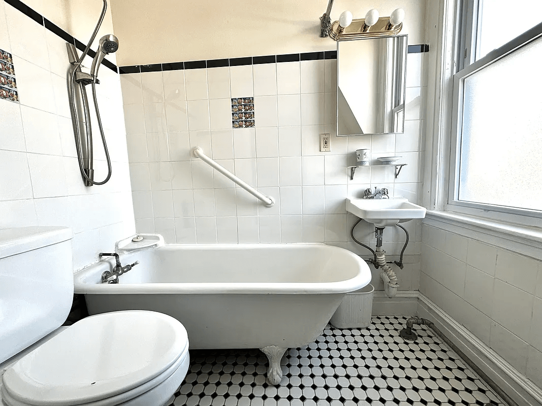 bathroom with claw foot tub and white tile on the walls