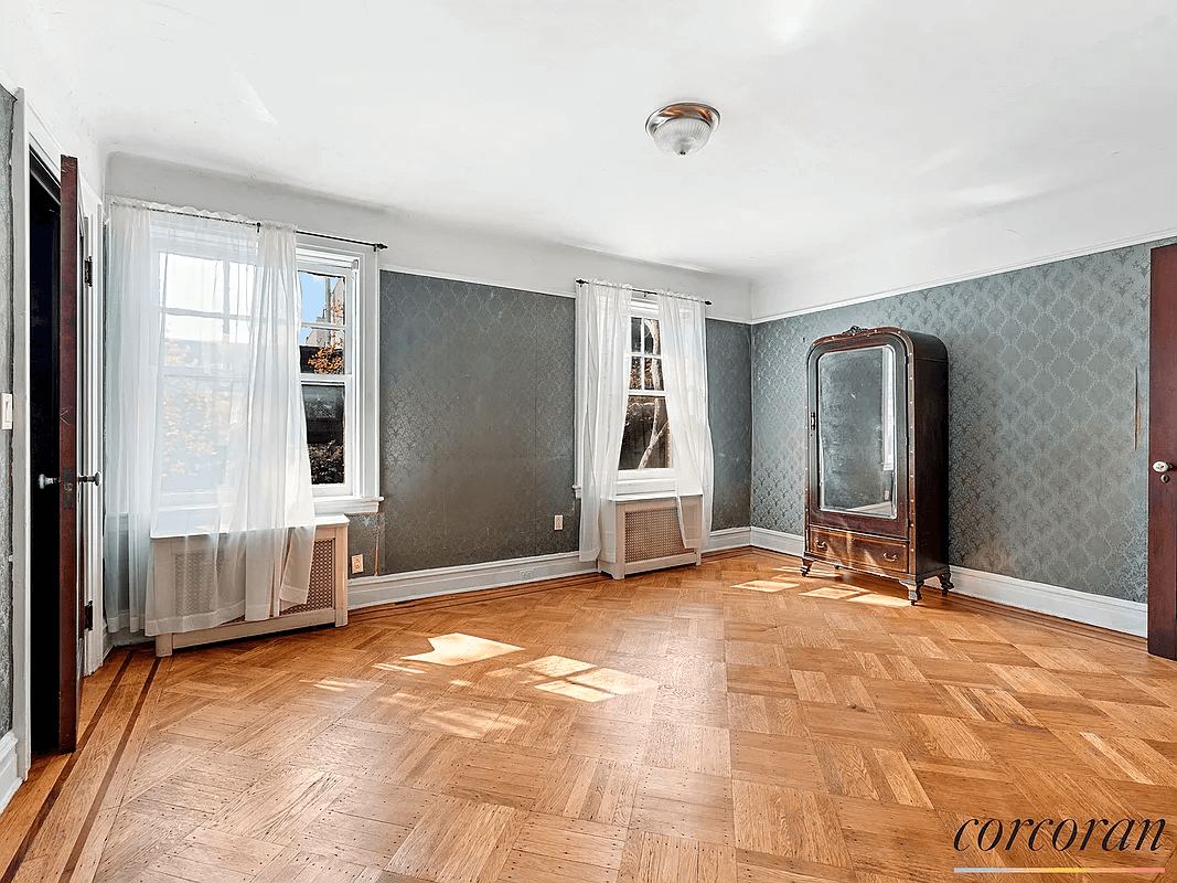 bedroom with green wallpaper and wood floor