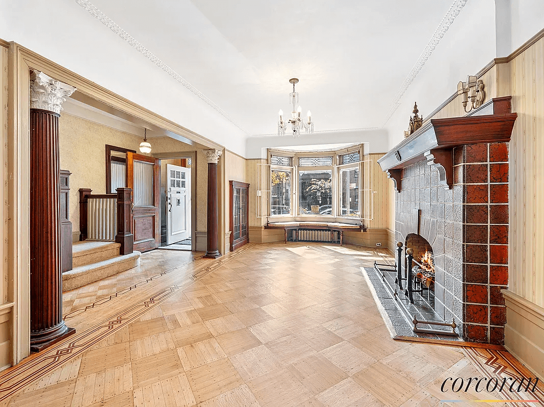 parlor with a tiled fireplace, plasterwork and a bay window