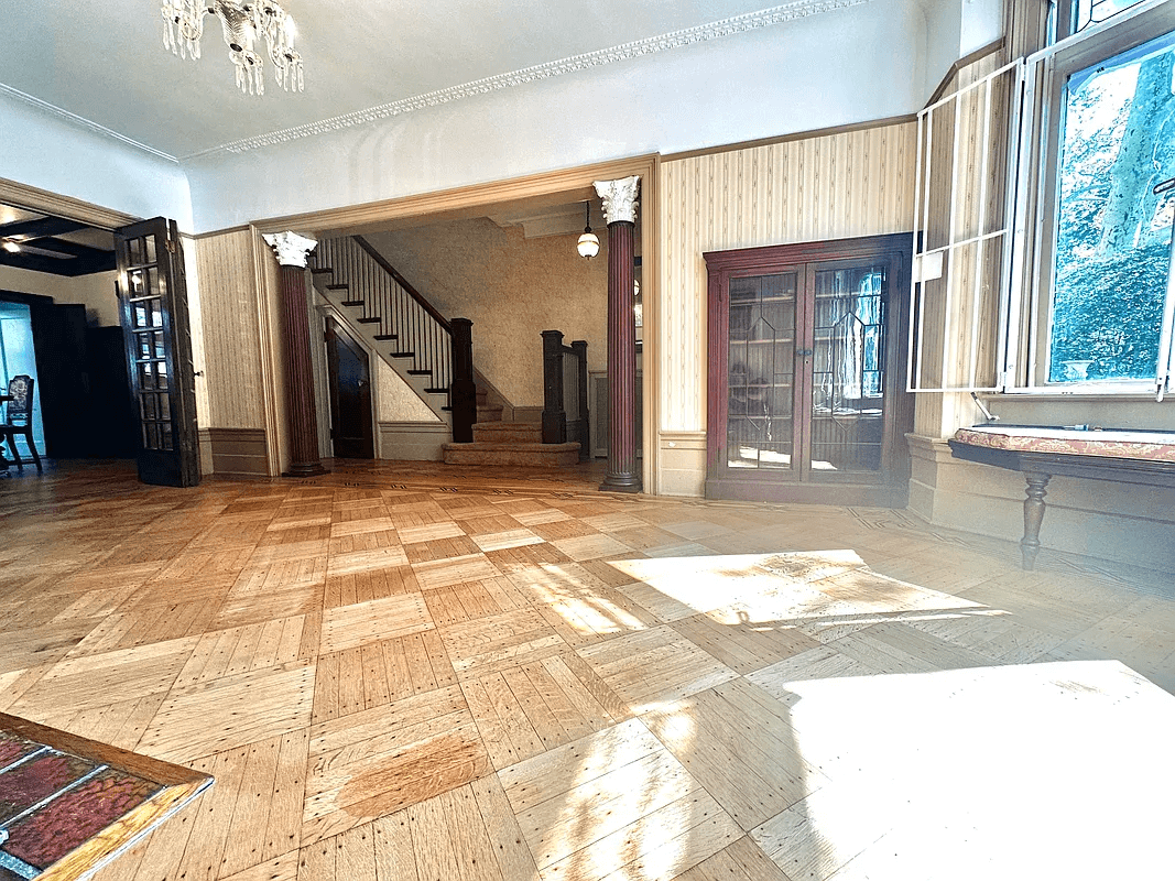 parlor with columns on either side of a doorway leading to the entry hall