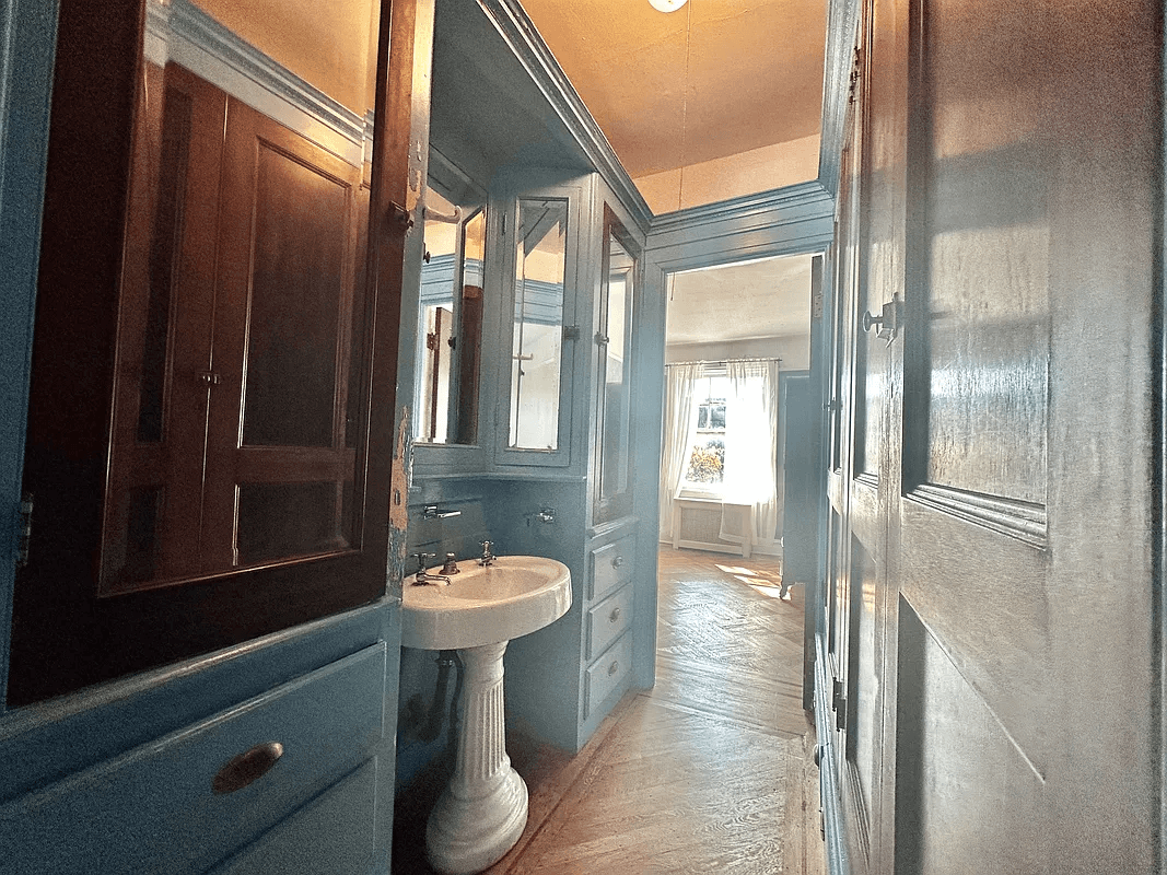 passthrough with blue cabinets and a sink