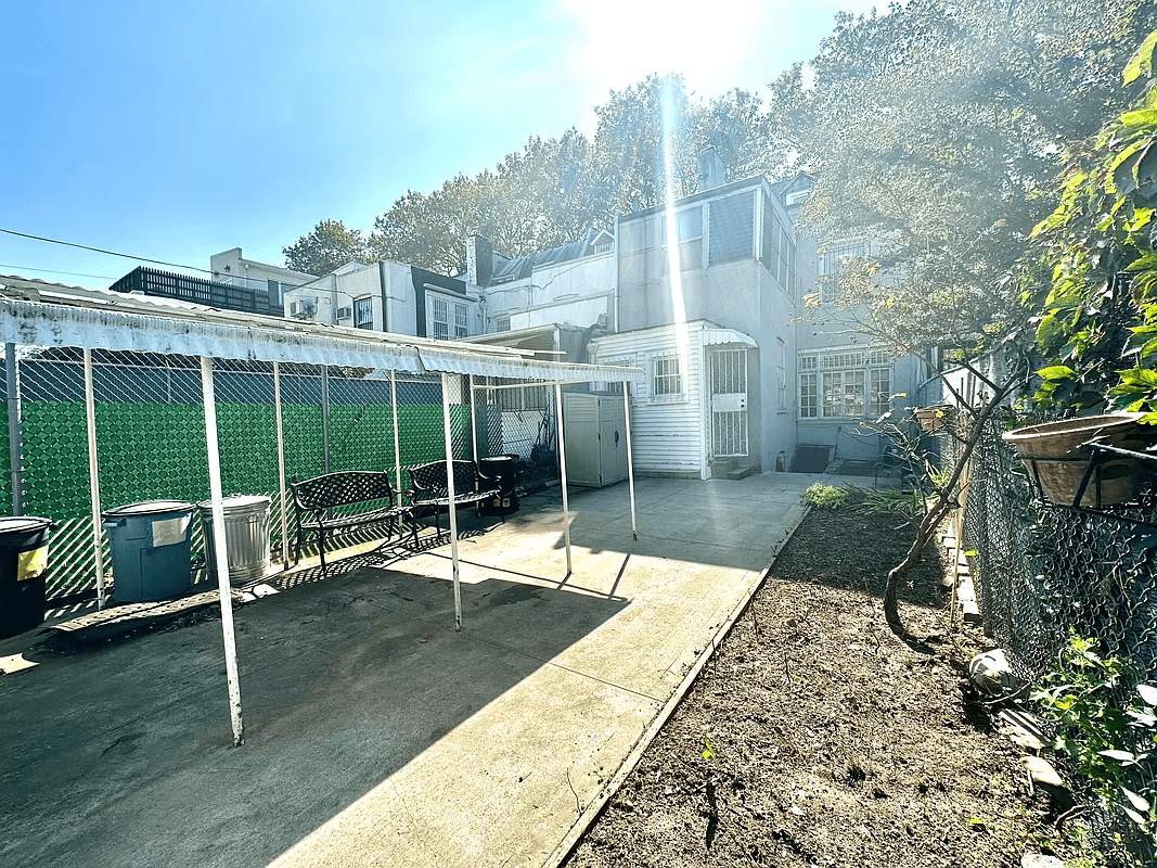 paved rear yard with a planting bed