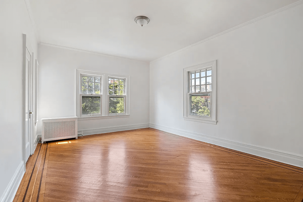 bedroom with two exposures and wood floor with inlaid border