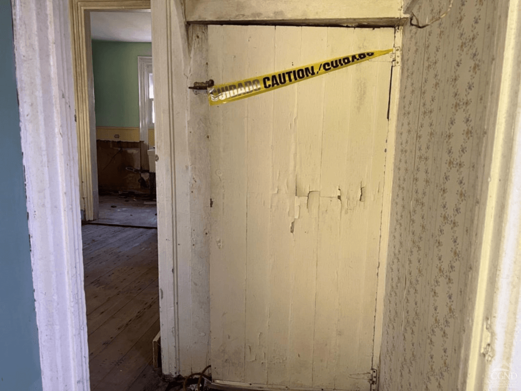 caution tape wrapped around a wood door to the cellar