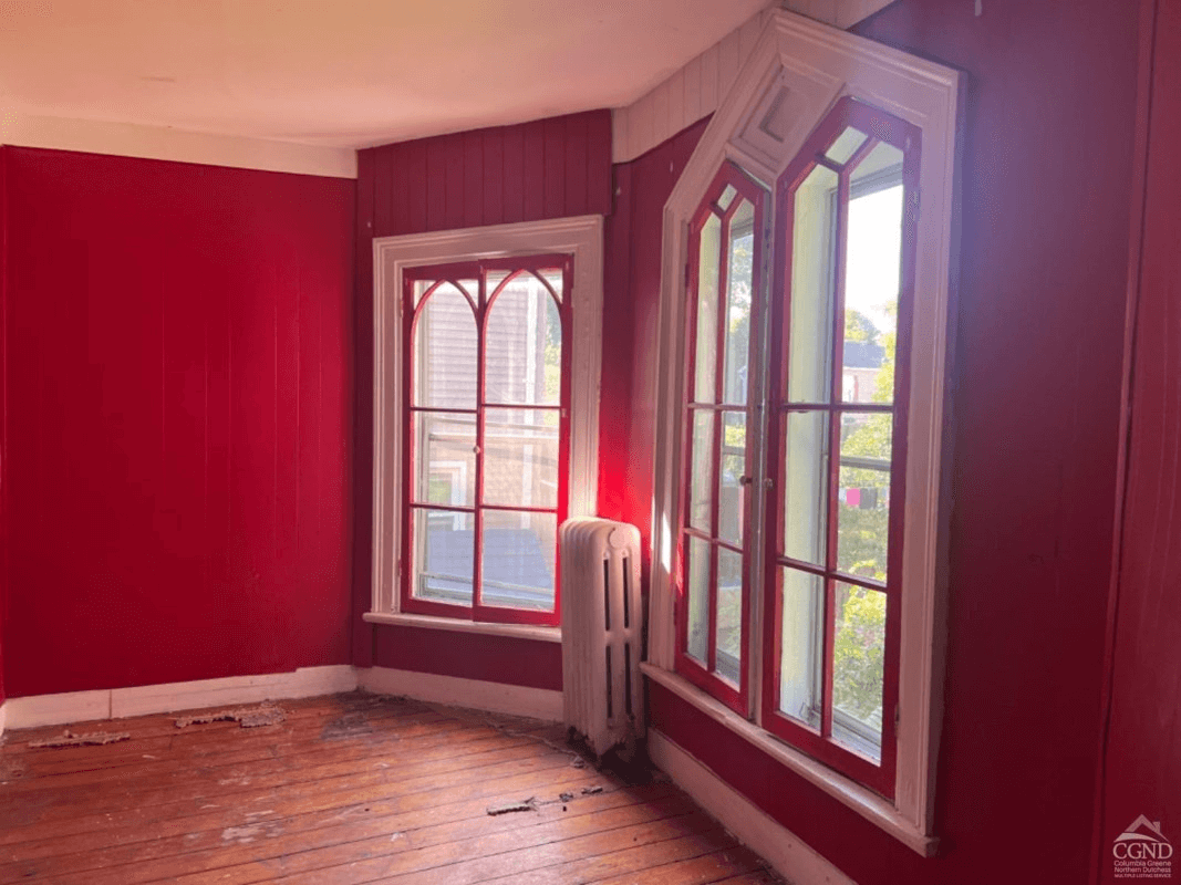 bedroom with red walls and gothic windows