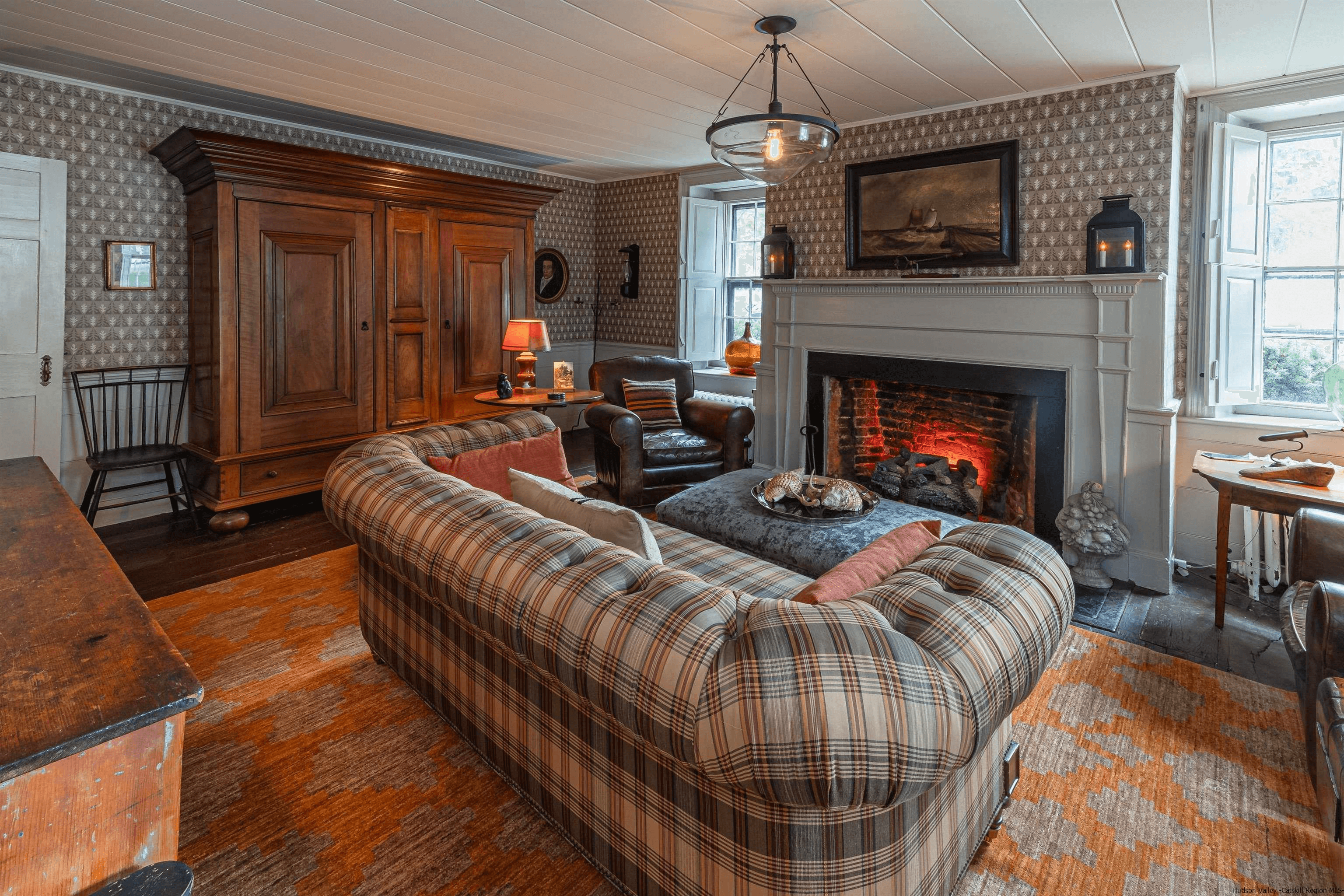 living room with mantel and wallpaper