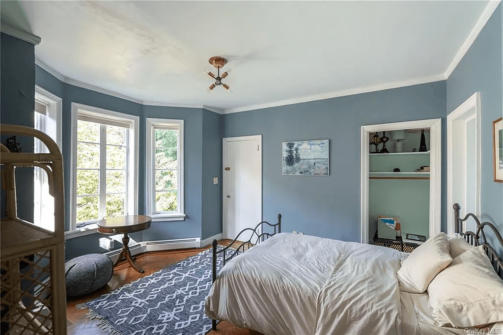 bedroom with closet and baseboard heating