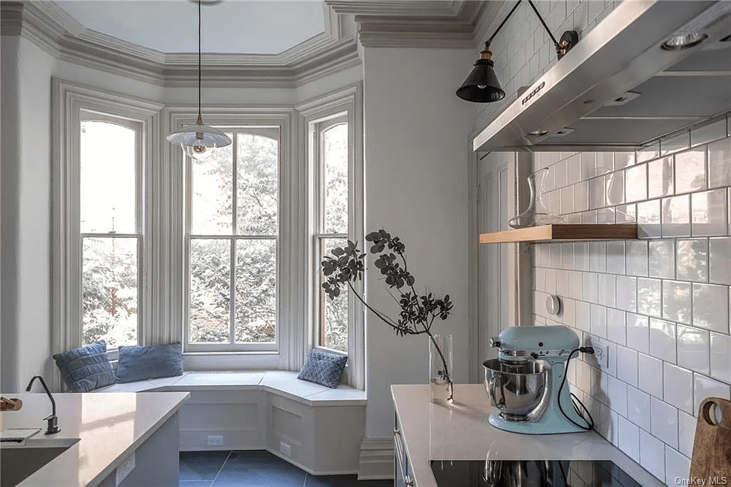renovated kitchen with white tile walls and a window seat