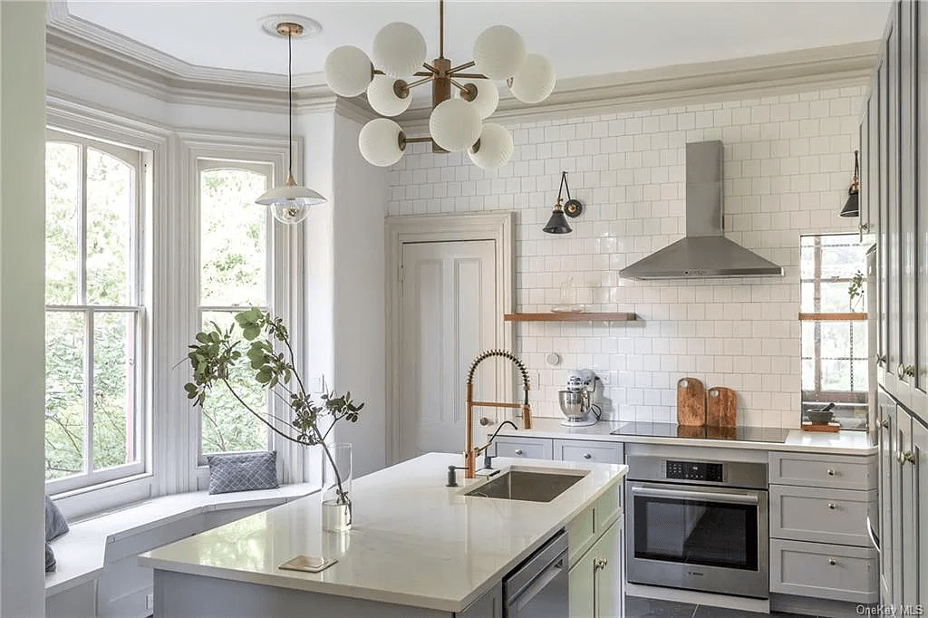 renovated kitchen with white tile on walls and pale gray cabinets
