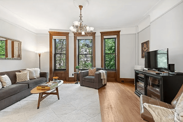 living room with three windows, picture rails and a ceiling medallion