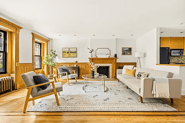 living room with wainscoting, wood floors, mantel