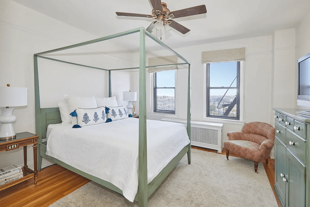 bedroom with ceiling fan and two windows, one with a fire escape