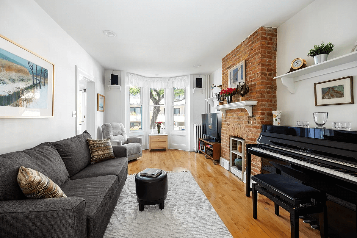 living room with exposed brick chimney wall, white walls and recessed lighting