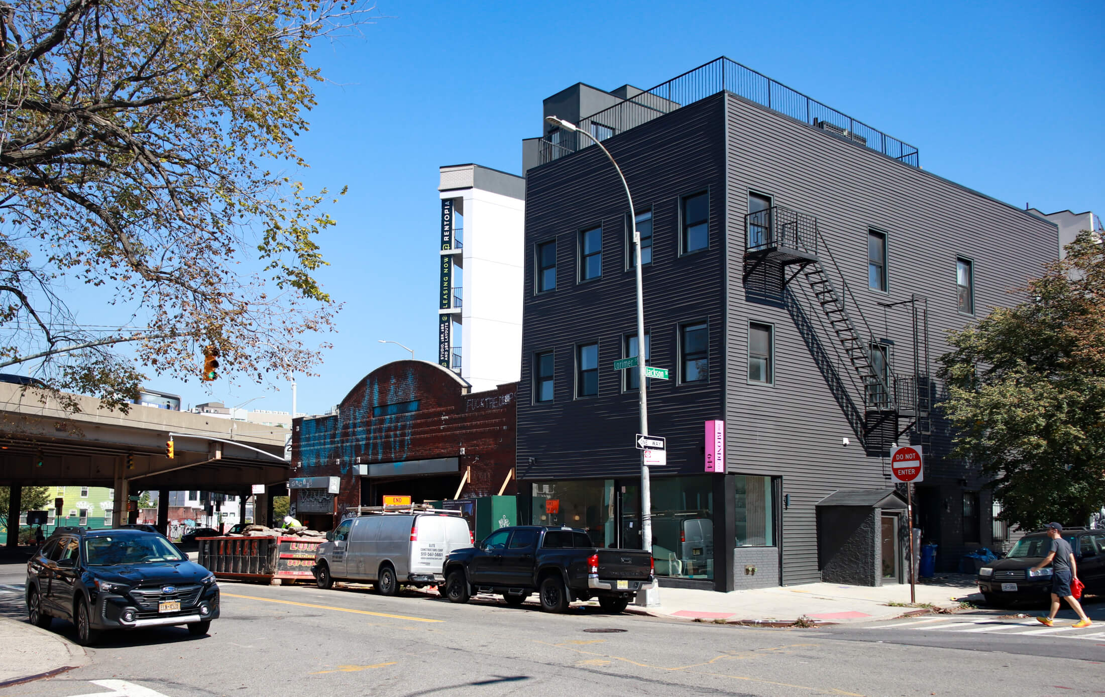 view of garage building with dumpster out front and bqe in the background