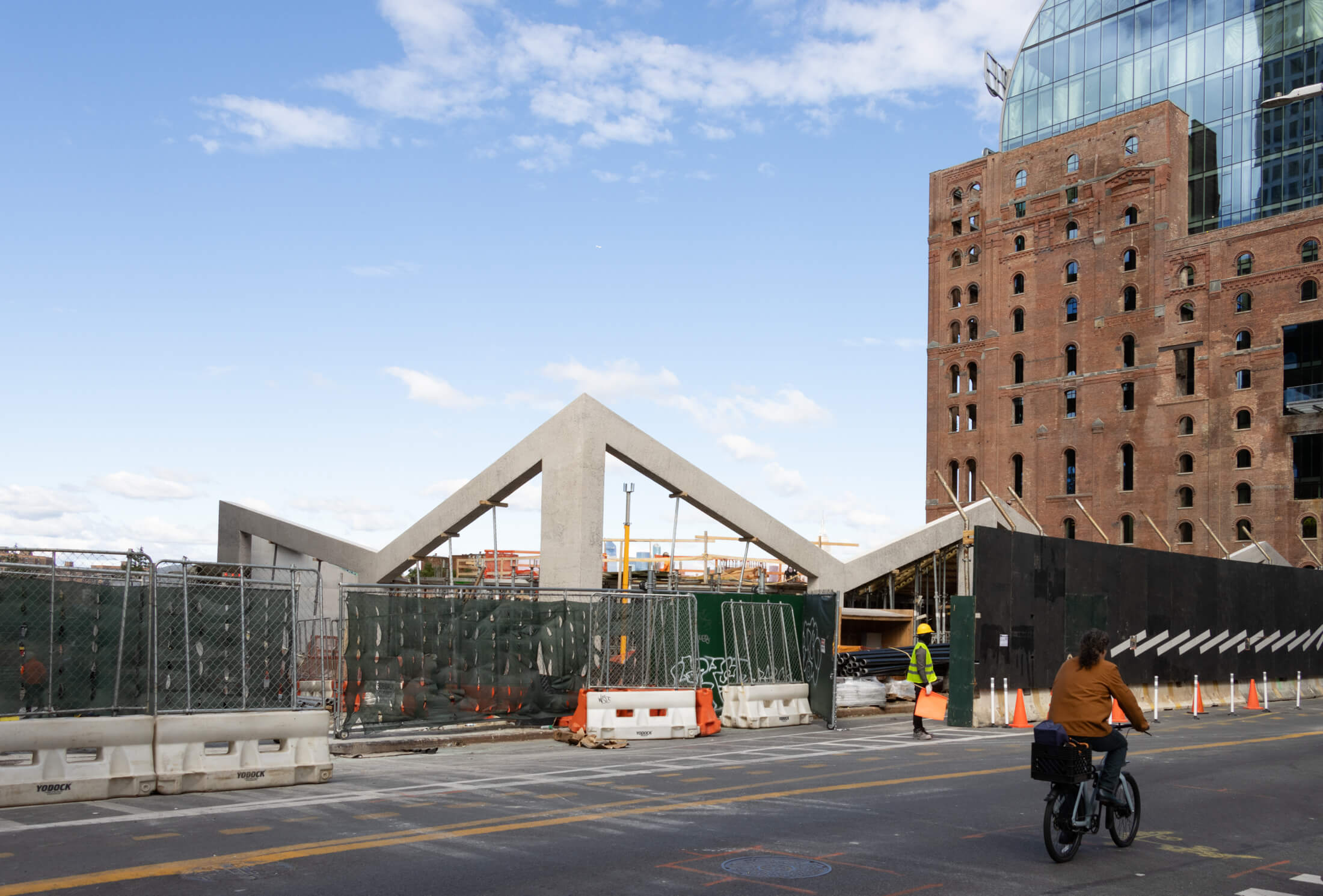 view along kent avenue showing ice rink under construction with refinery in the background