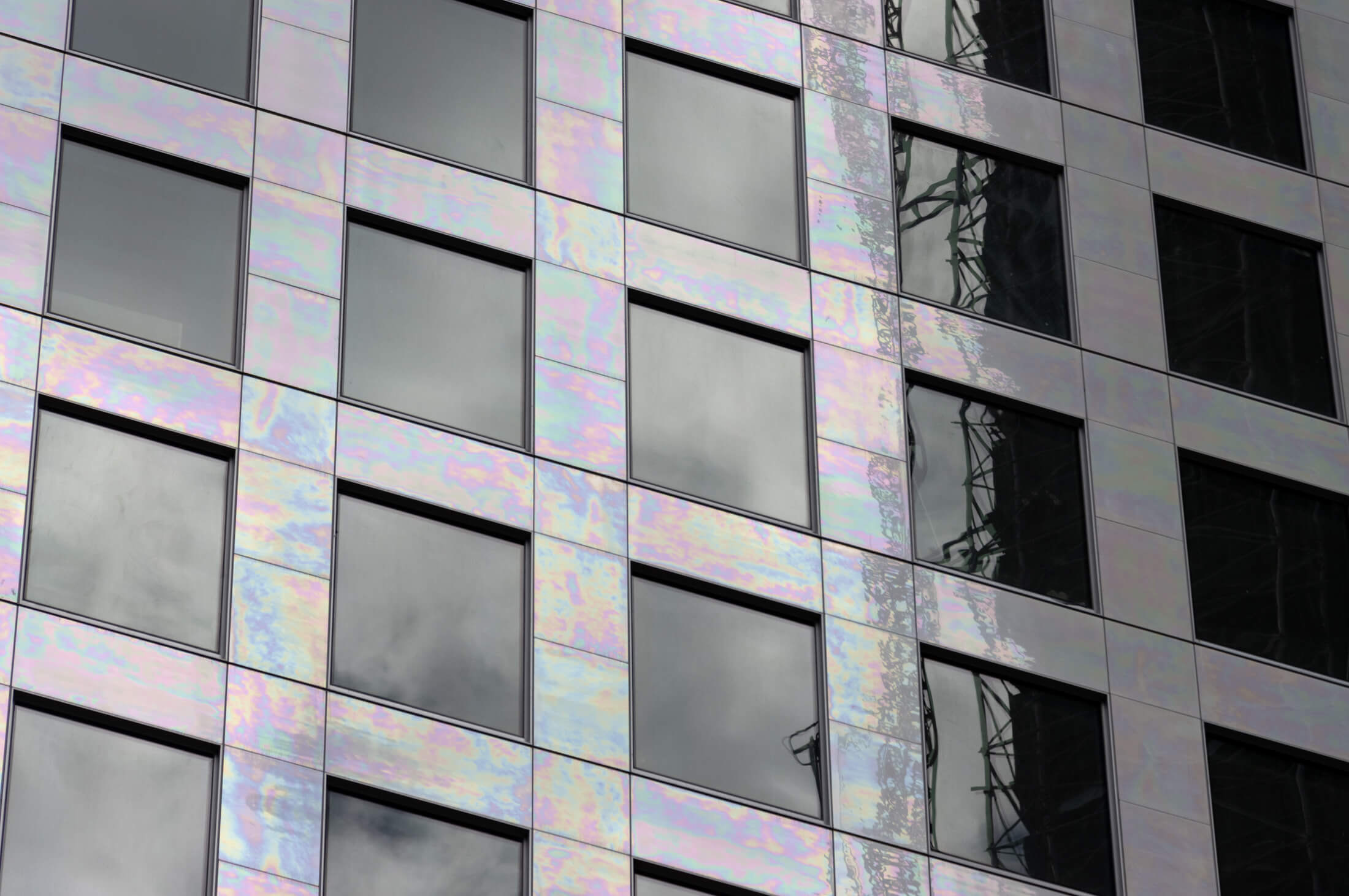 the iridescent porcelain tile on the facade shimmers with multiple colors in the sun