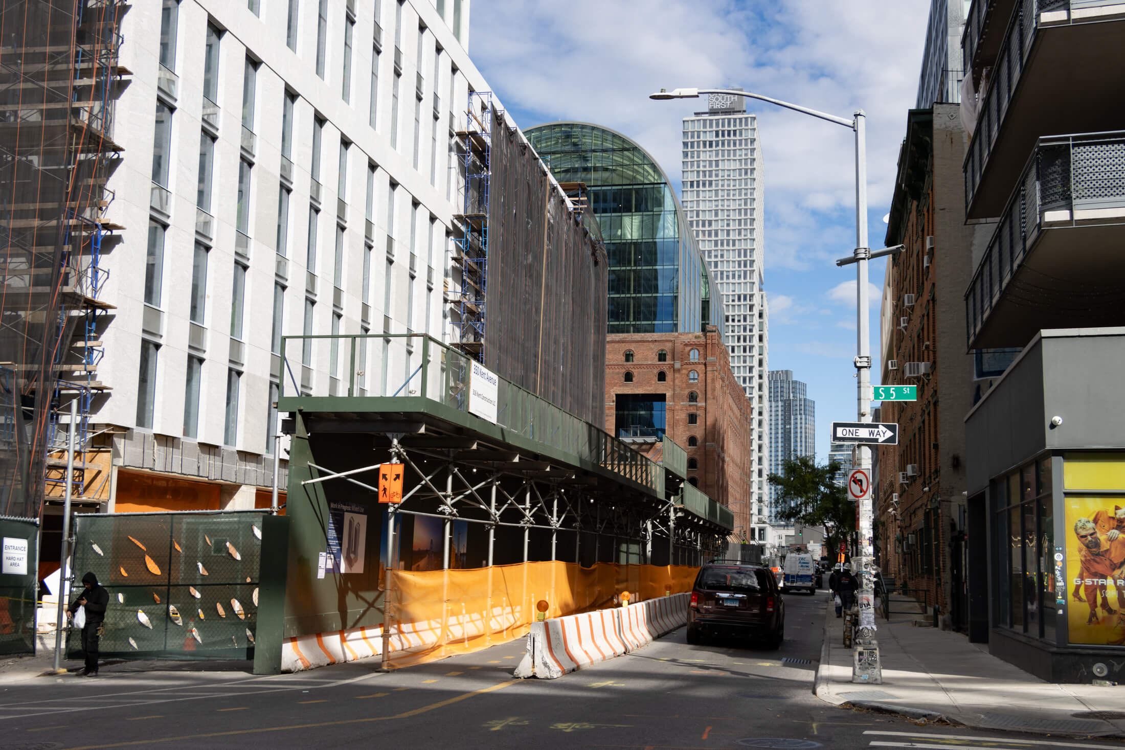 view on kent avenue showing the stone base of one domino square with refinery behind