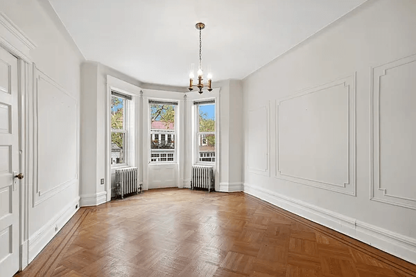 parlor with wall moldings and wood floors