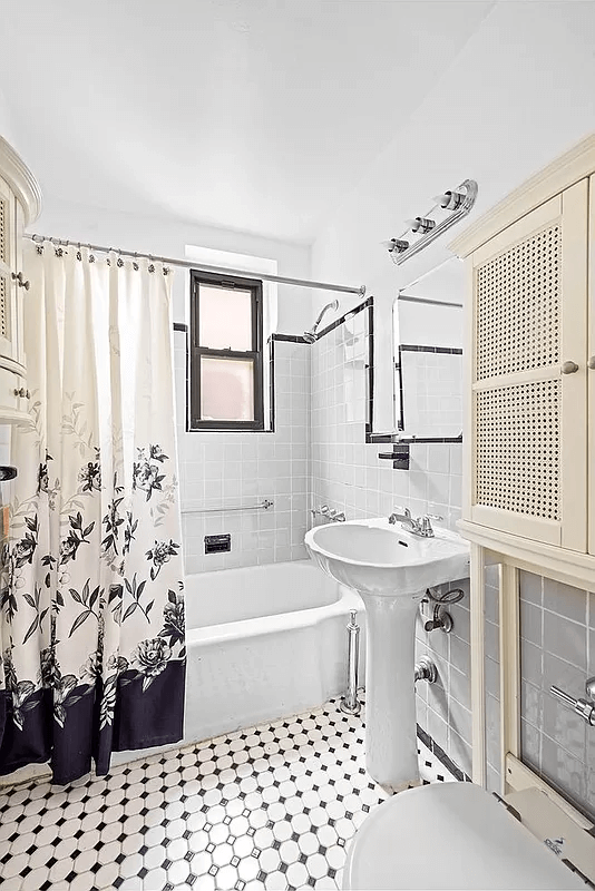 bathroom with black and white floor tile and white fixtures