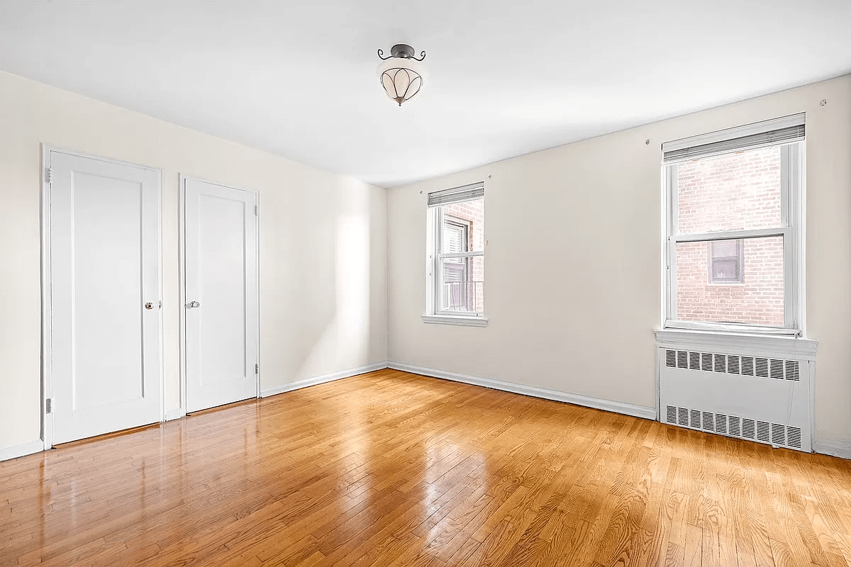 bedroom with wood floor and two windows