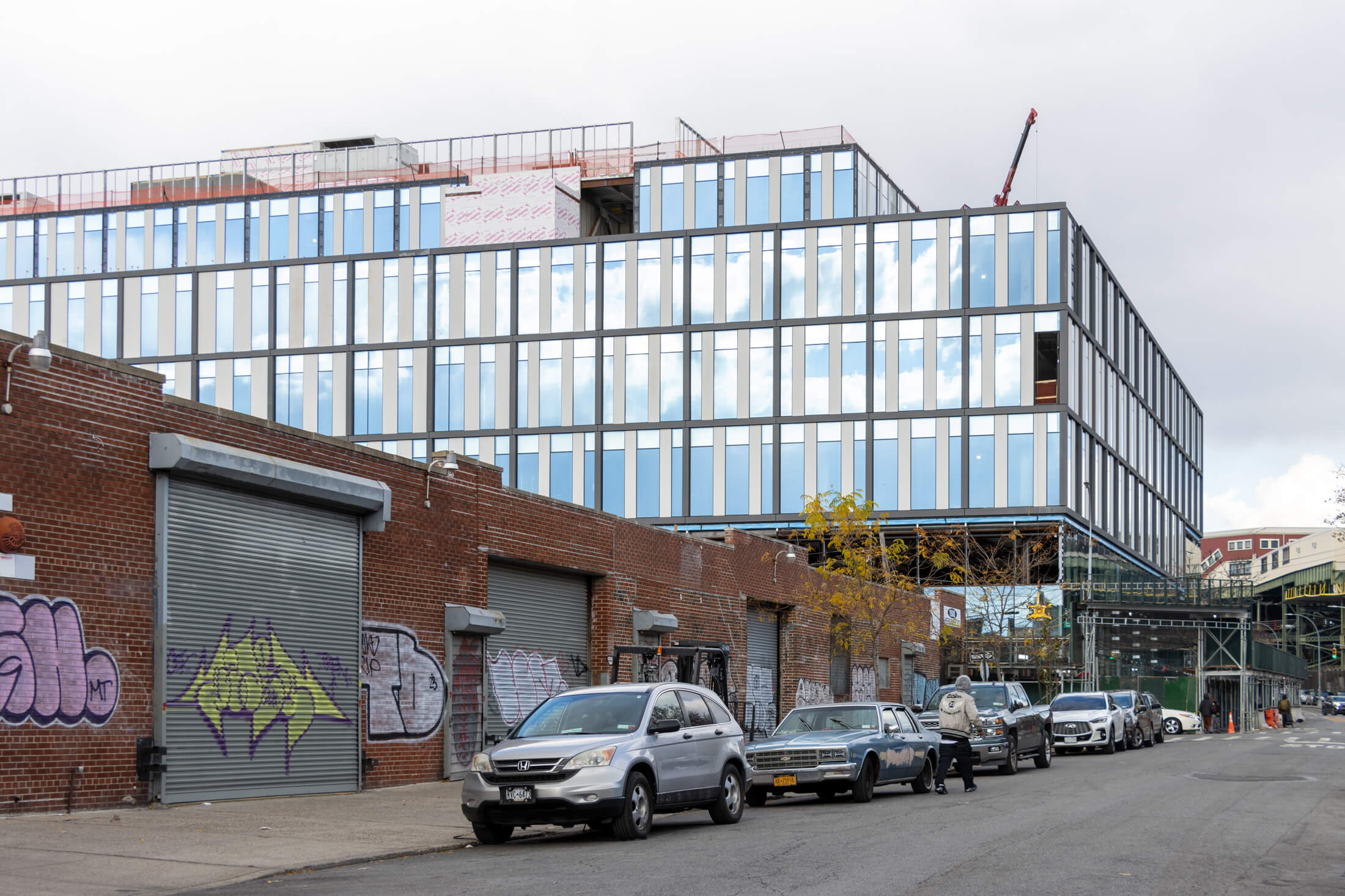 new building under construction with one story brick industrial buildings in the foreground