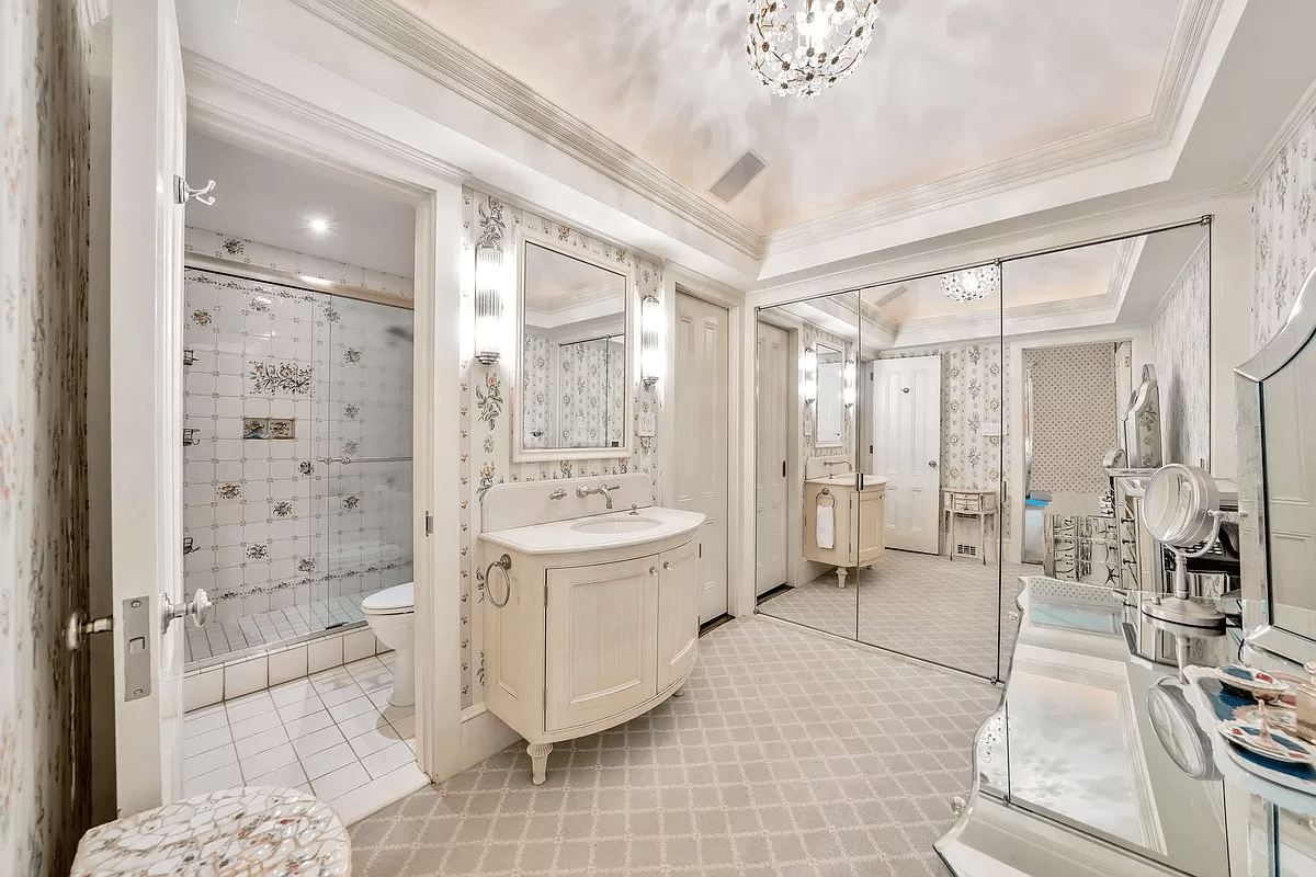 dressing room witha sink, glass doors to closet and another door to a bath