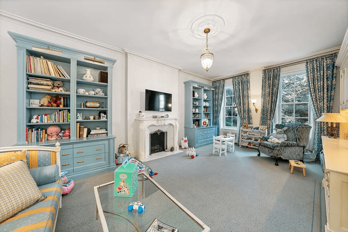 bedroom set up as a living room with a mantel and gray carpet