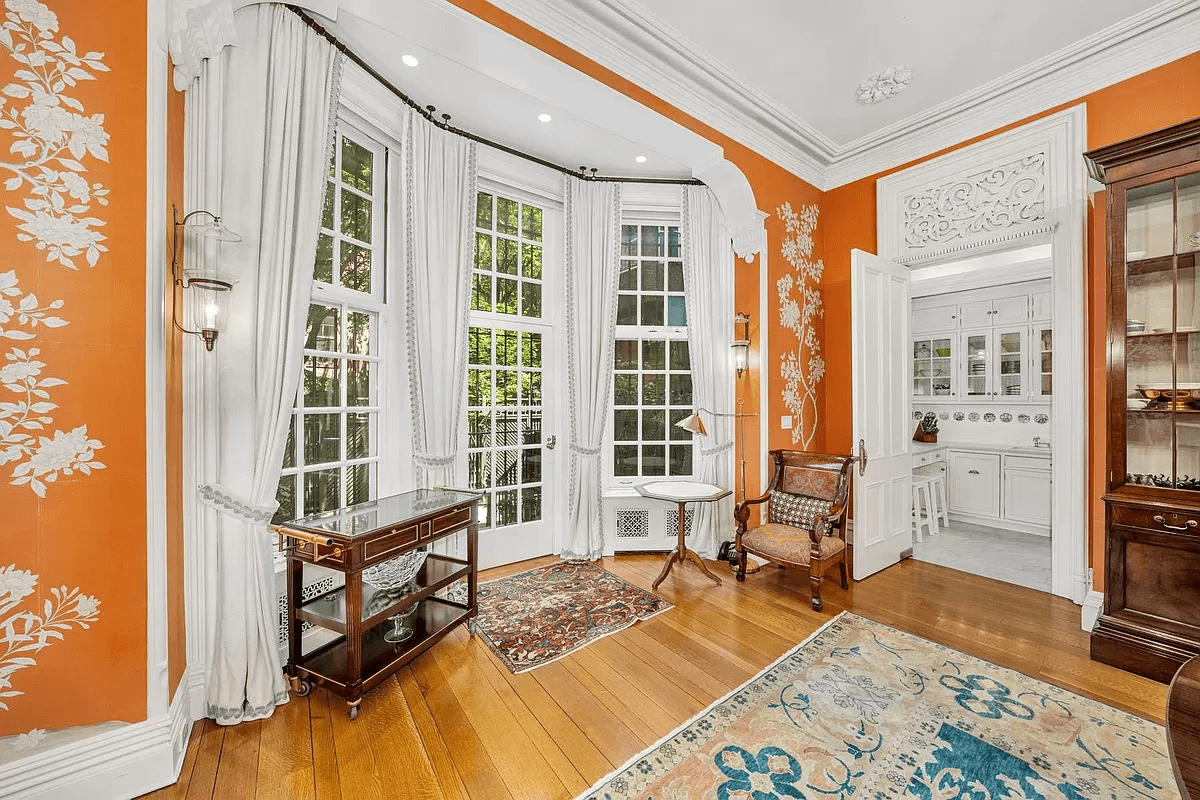 dining room with orange walls and a door to the kitchen