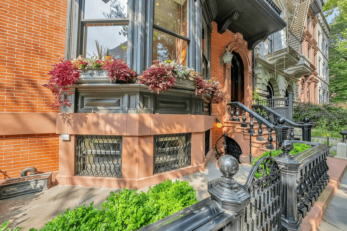paved front yard surrounded by iron fence