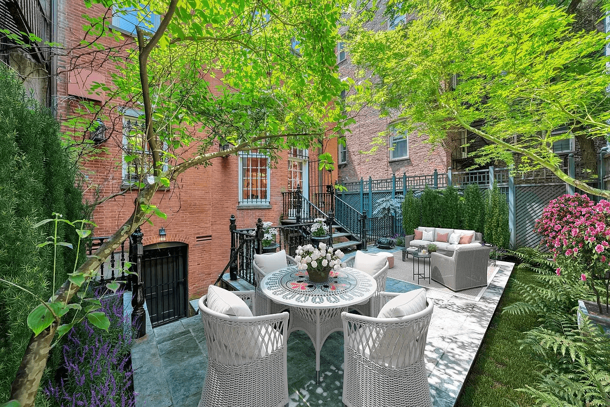 rear yard with stone pavers and virtually staged seating area