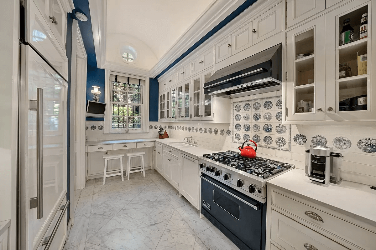 kitchen with white cabinets and decorative blue and white tile