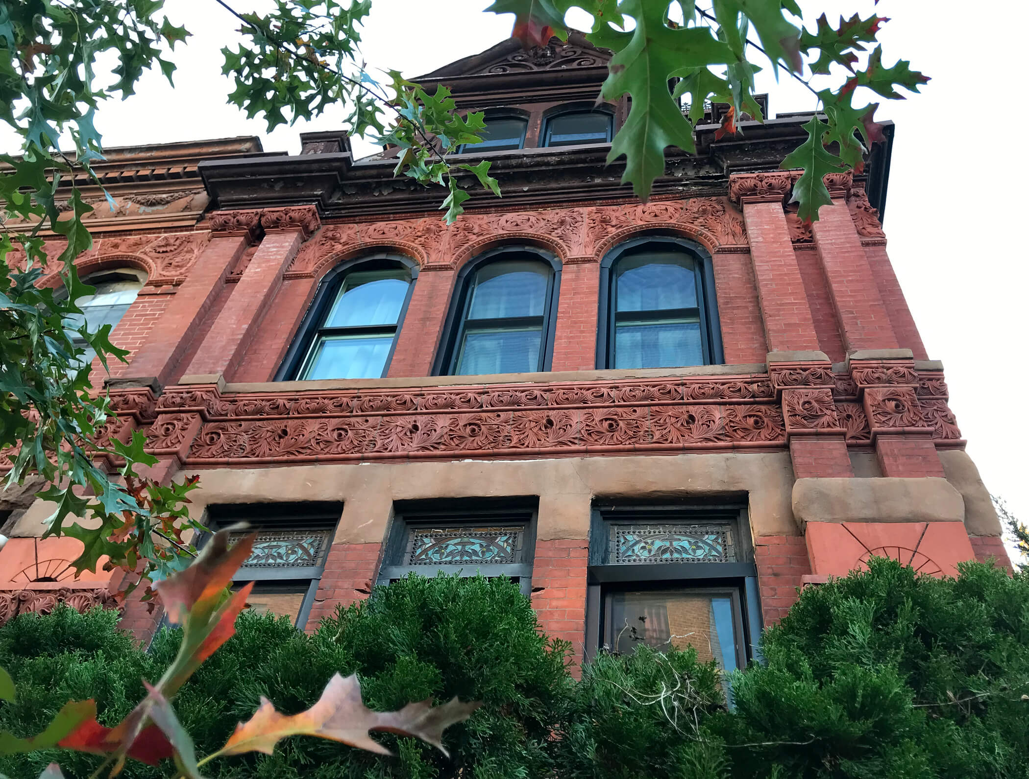Queen Anne-style brick and terra-cotta corner house in Bushwick in the fall