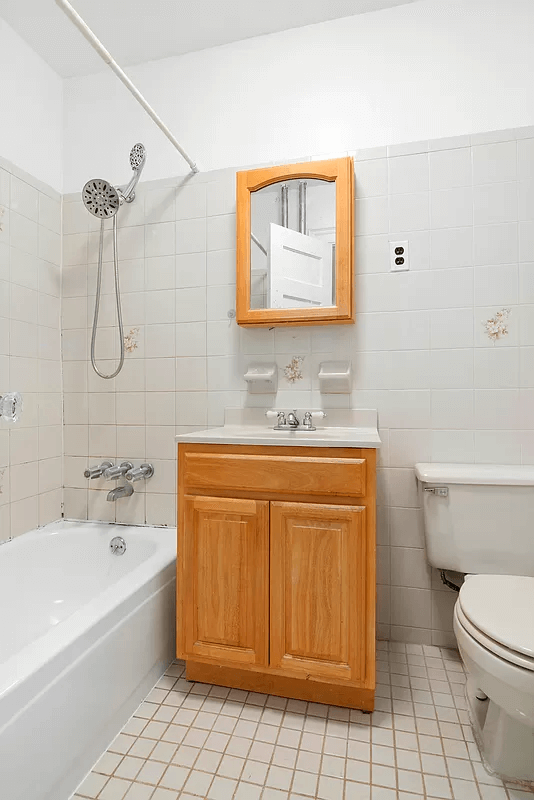 bathroom with white fixtures and wood vanity