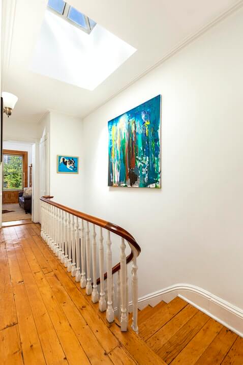 upstairs hall with curved stair railing and a skylight