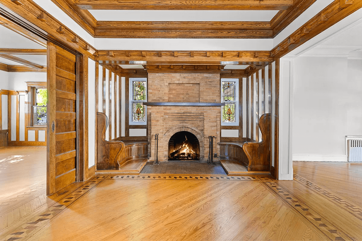 inglenook in the great room with stained glass windows, benches and a brick fireplace