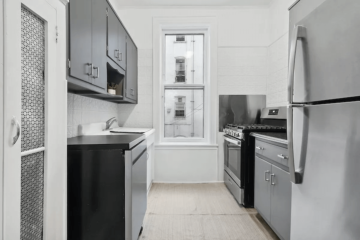 kitchen with dark cabinets, a vintage sink and tin panels on the walls