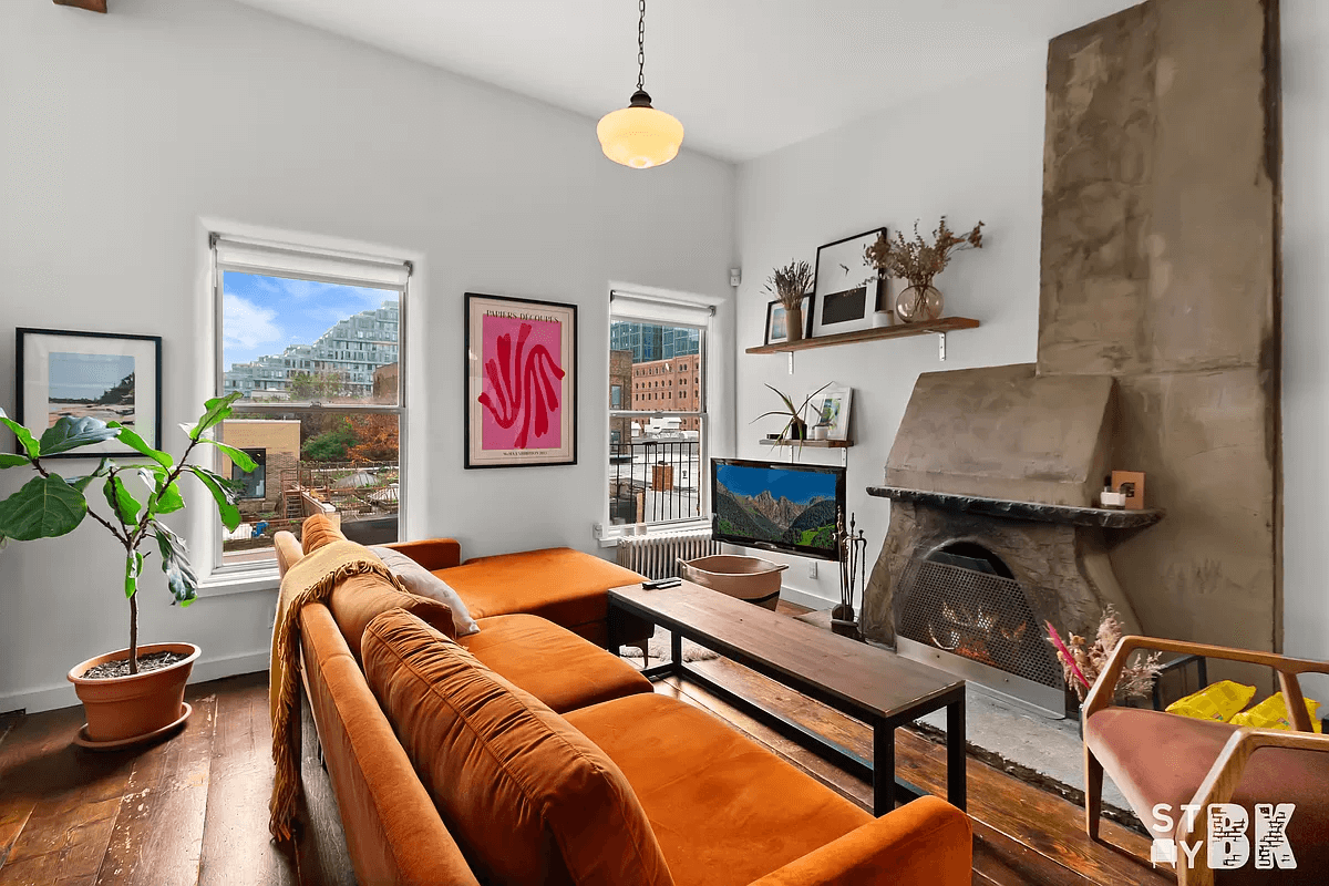 living room with two windows and a stone fireplace