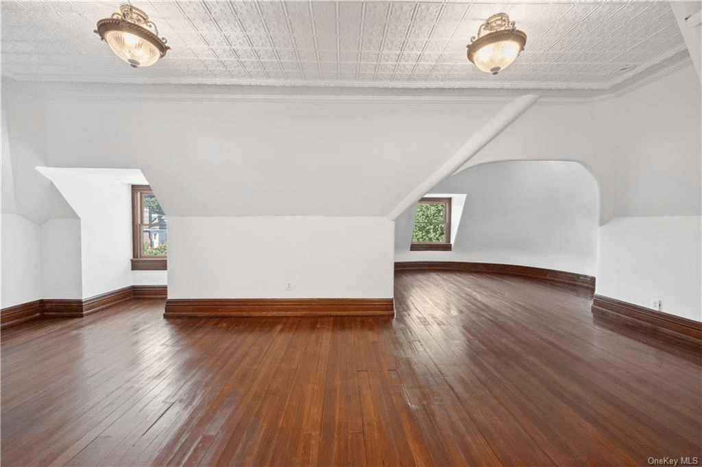 top floor bedroom with sloped ceilings and wood floor