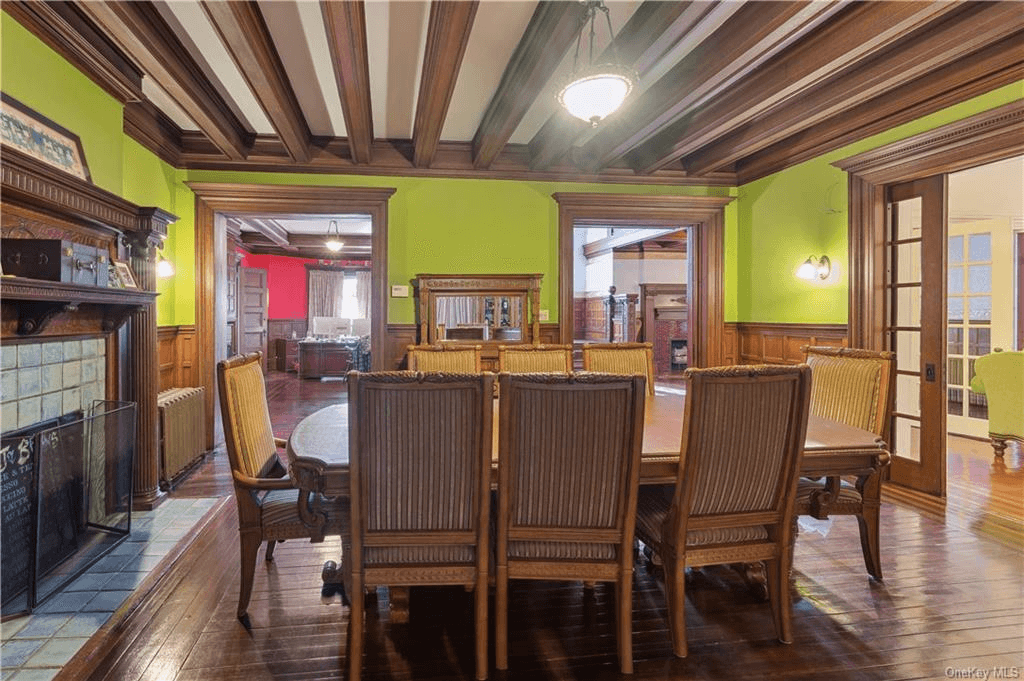 dining room with beamed ceiling and wainscoting