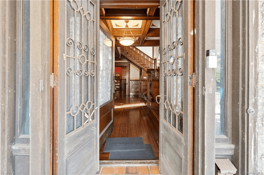 view from entry door into foyer with glimspe of coffered ceiling