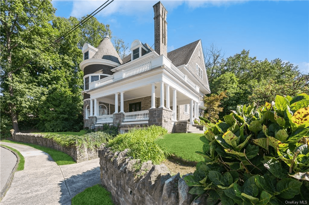 exterior of the house with stone wall around yard