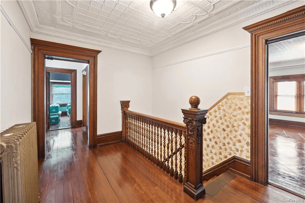 upper hallway with tin ceiling and wood floors